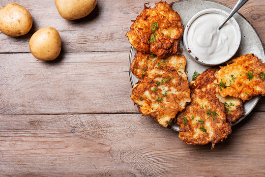 Fried potato latkes with sour cream. Hash browns.