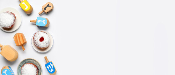 Hanukkah composition with dreidels and donuts on white background