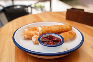 Deep-fried cheese sticks with cherry sauce.