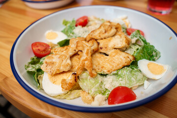 Caesar salad with chicken on a plate.