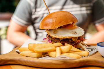 Burger on a skewer with French fries.