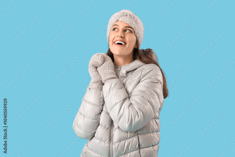 Canvas Prints Young woman in winter clothes on blue background