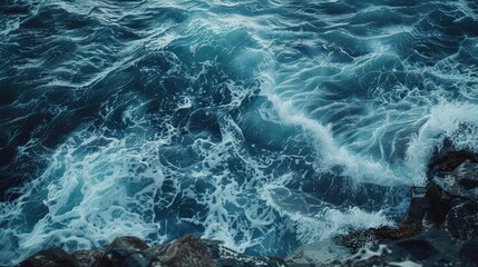 Deep blue ocean waves crashing on a rocky shore, with foamy textures