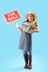 Little farmer with fresh food and FOR SALE sign on blue background