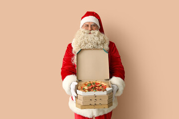 Santa Claus with boxes of tasty pizza on beige background