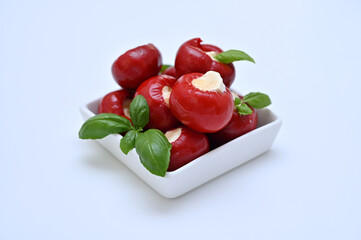 appetizer antipasti peppers with cheese and basil in a bowl on a white background