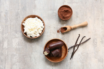 Bowl of curd, powdered coffee and tasty cottage cheese bars with vanilla on grey grunge background