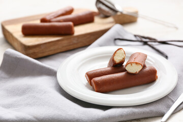 Powdered coffee and tasty curd bars on plate with vanilla on grey background