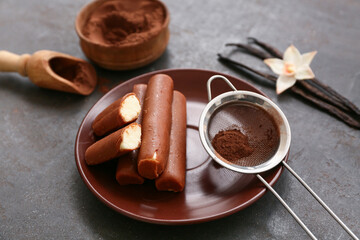 Plate with curd bars and powdered coffee on black grunge background