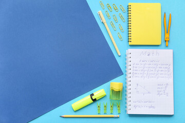 Notebook with school stationery on blue background with space for text