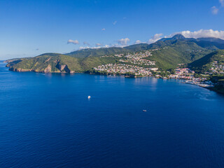 Drone view of the Bay in front of Case-Pilote with diving boats in the ocean, Martinique, West Indies, France