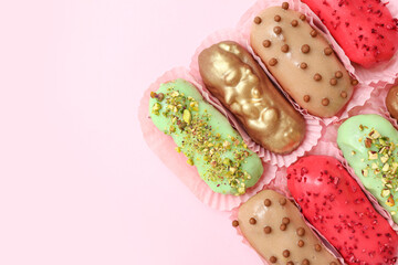 Composition with different glazed eclairs on pink background