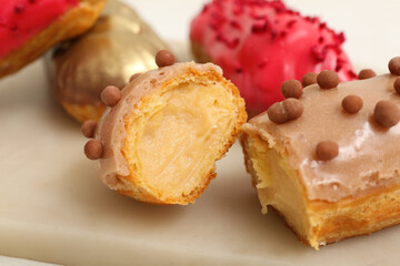 Sweet eclairs on light  background, closeup