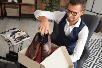 Young businessman with new shoes in store