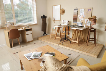 Interior of stylish atelier with tailor's workspace, mannequin and mood board