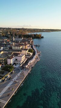 Aerial view of the Christmas markets along the lakefront of Lazise, Lake Garda, Italy. Vertical video, drone shot.