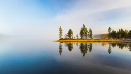 Quiet, calm and peaceful autumn frozen morning at the Finnish lake with breathtaking view to trees...
