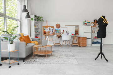 Interior of fashion designer's studio with workplace, sofa and mannequin