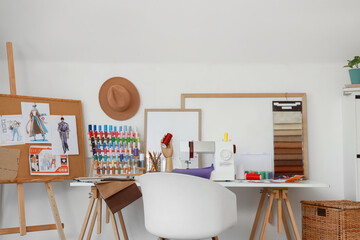 Interior of fashion designer's studio with workplace and drawings