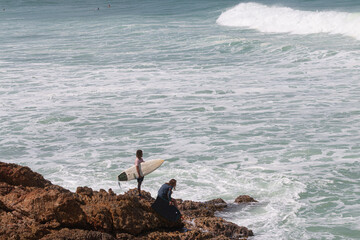 A surfer and bodyboarder about to get in the water at VVF, Anse l'Etang, Tartane, Martinique, West Indies, France