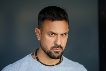 Portrait of the serious handsome man. A Hipster guy model headshot. Male serious face. Handsome serious man. Confident serious male model. Man looking proud. Closeup face of man outdoor. Elegant guy.