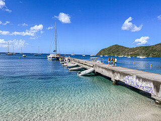 Family walking down a pier towards a Sailboat cruise, Grande Anse, Martinique, West Indies, France