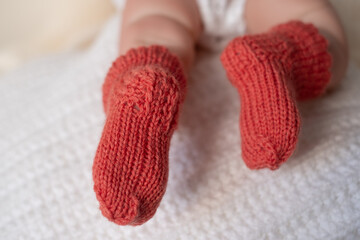 Sweet baby feet in cozy handmade knitted booties resting on a soft blanket during a calm afternoon at home