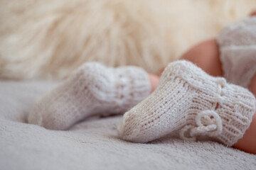 Soft knitted baby booties on a cozy blanket, capturing the essence of newborn comfort in a serene setting