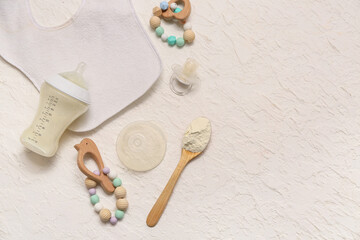 Feeding bottle with milk for baby, pacifier, teethers and bib on light background