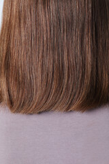 Cropped portrait of young woman with luxurious short hair posing indoor. Vertical.