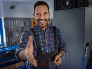 Repairman offering handshake in workshop