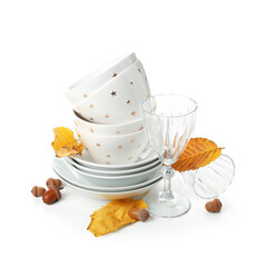 Stack of dishes with autumn decor and acorns on white background
