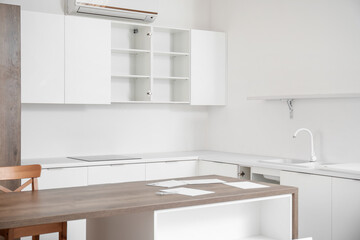 Interior of light kitchen with counters and table