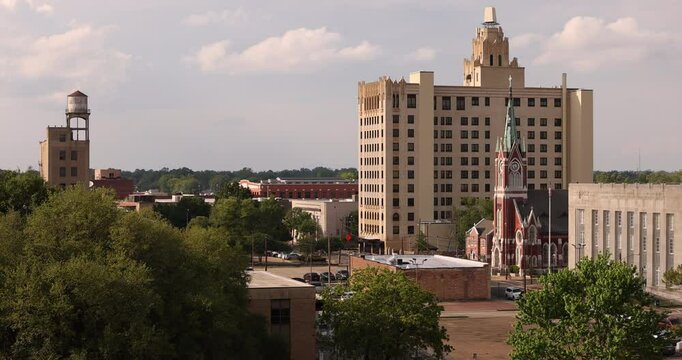 Monroe, Louisiana, USA - April 4, 2024: Afternoon sunlight shines on the historic buildings and church in the skyline of downtown Monroe.