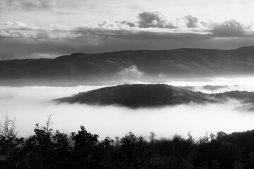 black and white photo of fog in the valley  with a mountain top showing  Steamboat Springs Colorado