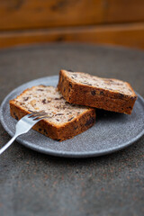 Freshly sliced banana bread served on a rustic plate with a fork ready for tasting in a cozy kitchen setting