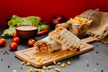 Juicy BBQ chicken wrap with corn filling, cut and styled on board. Ideal for fast-food lovers