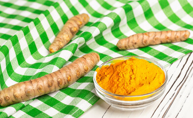 turmeric root and ground turmeric in a bowl