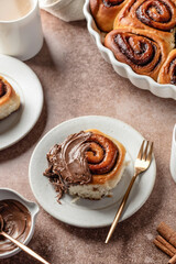 Chocolate swirl buns with hazelnut chocolate filling. Chocolate cinnamon buns and coffee served for breakfast on brown background