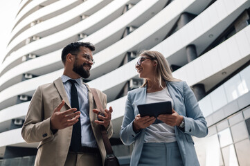 Businesspeople discussing while walking outside office building