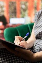 Psychology expert writing the progress of a client during therapy meeting, offers counseling to...
