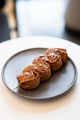 Three sweet pastry swirls on a gray plate at a modern cafe