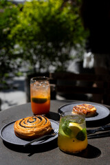 Enjoying delicious pastries and refreshing drinks in a cozy outdoor café setting on a sunny day