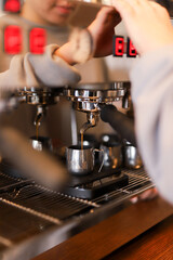 A barista extracts espresso at a café using a sleek coffee machine during morning hours, showcasing skill and precision