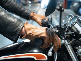 close-up of a motorcyclist's hand dressed in a brown leather glove