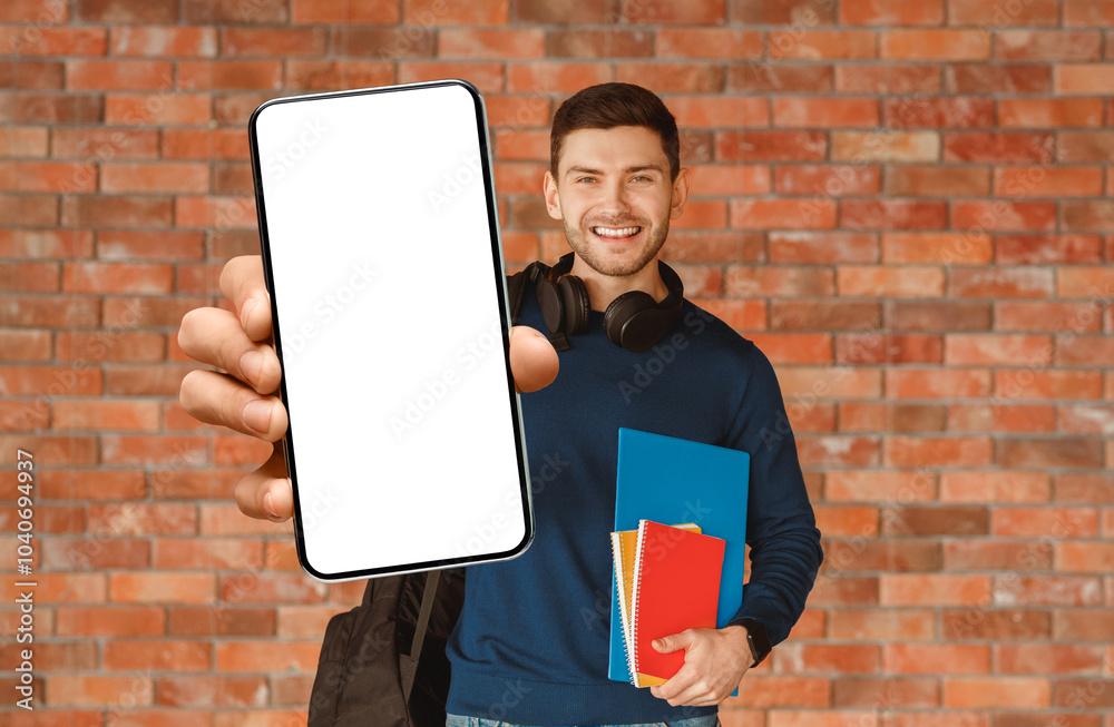 Poster modern student. happy guy with backpack holding smartphone and notebooks smiling to camera standing 