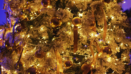 Christmas tree is adorned with golden baubles and warm twinkling lights, creating a festive atmosphere. The image evokes the spirit of christmas with its warm and inviting ambiance
