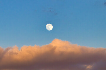 Almost full moon rising into the maui sky at sunset.