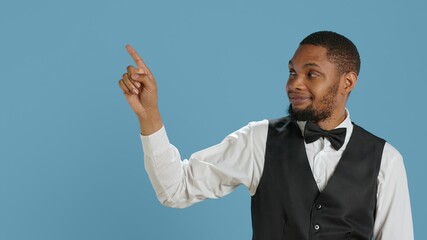 Doorkeeper bellhop pointing at something to left or right sides, indicating the direction for...