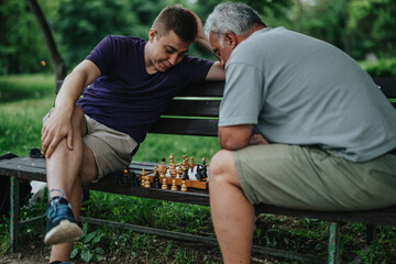 Two men are deeply focused, playing a chess game on a park bench, surrounded by green nature,...